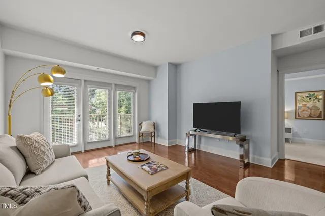 a living room with furniture a rug and a flat screen tv