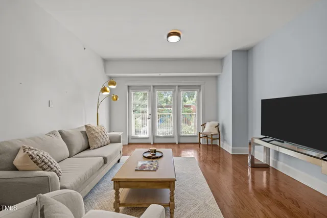 a living room with furniture flat screen tv and a large window