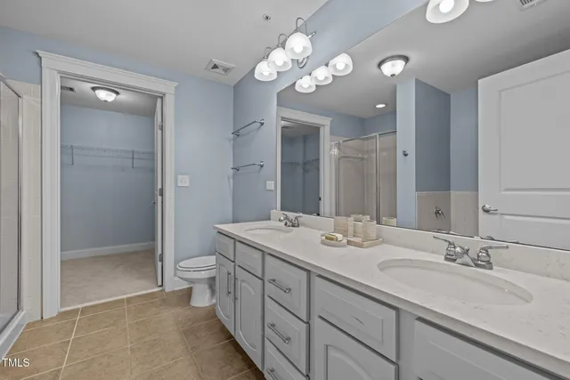 a bathroom with a double vanity sink mirror and shower