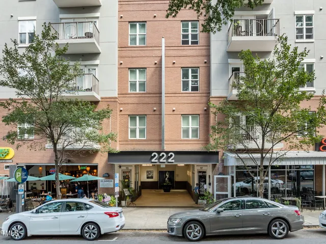 a front view of a building with cars