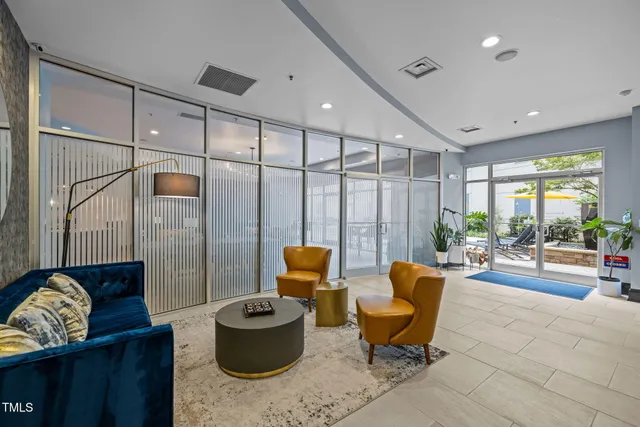 a living room with furniture a flat screen tv and kitchen view