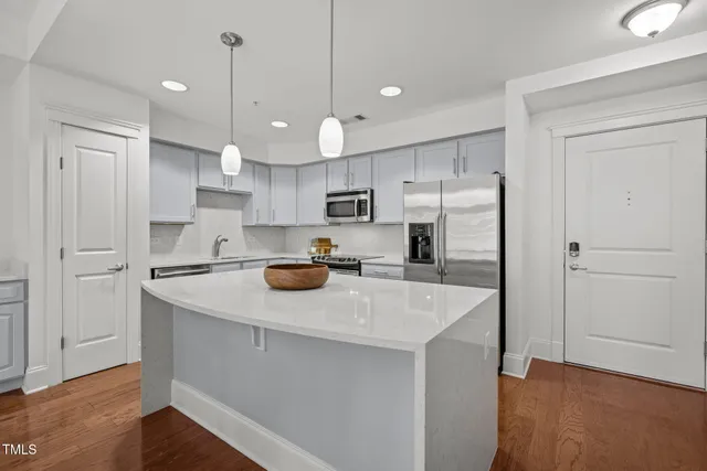 a kitchen with a sink a stove a refrigerator and a center island