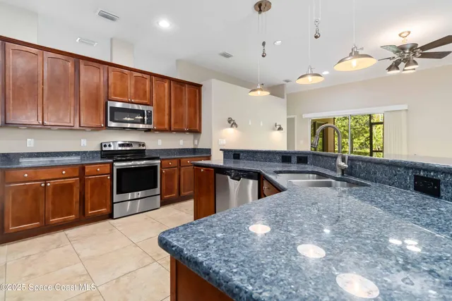 a large kitchen with a large counter top stainless steel appliances and cabinets