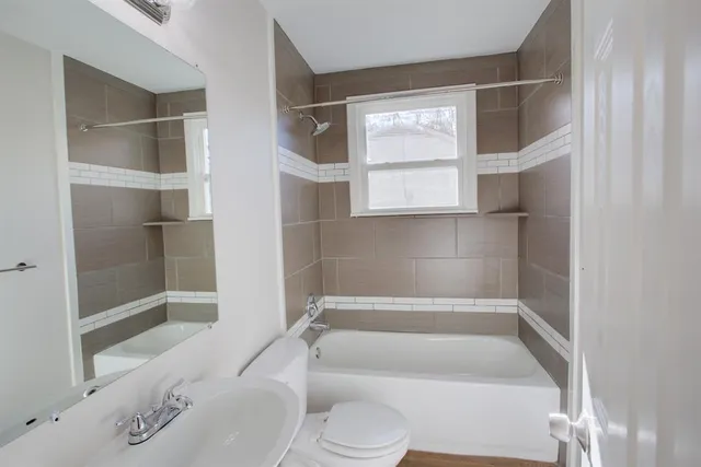 a bathroom with a toilet bathtub and window