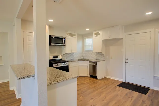 a kitchen with a refrigerator and a stove top oven