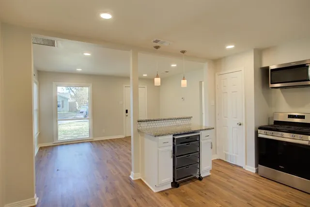 a kitchen with stainless steel appliances granite countertop a stove and a refrigerator