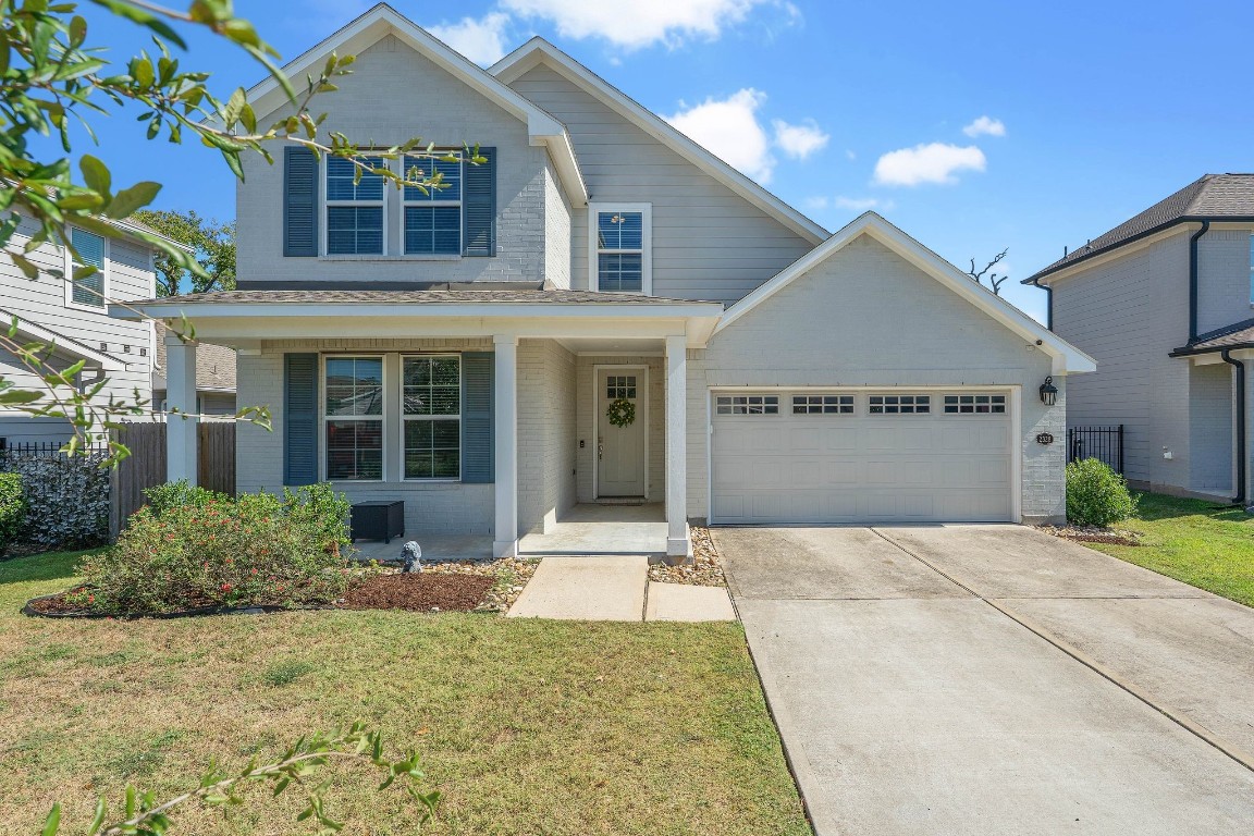 a front view of a house with a yard and potted plants