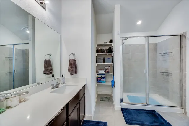 a bathroom with a double vanity sink a mirror and shower