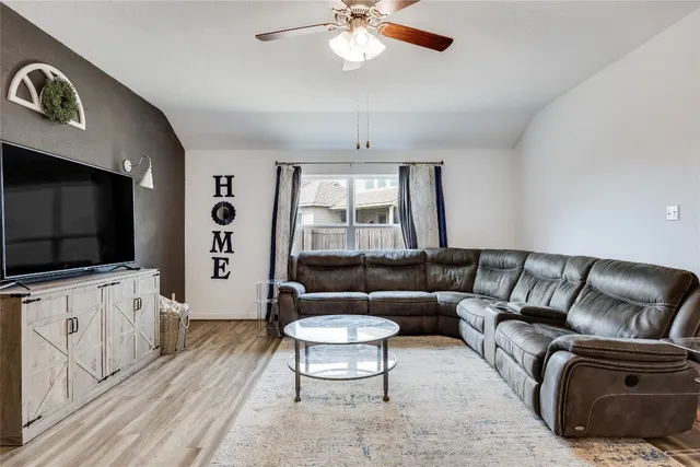 a living room with furniture a flat screen tv and a large window
