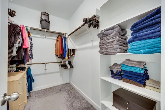 a view of walk in closet with clothes and shoes