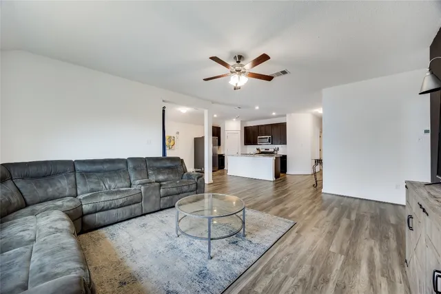 a living room with furniture and a wooden floor