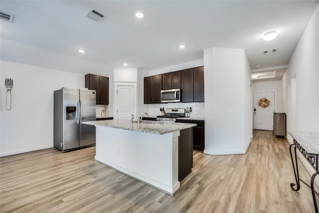 a kitchen with stainless steel appliances a refrigerator stove and microwave
