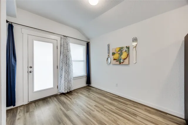 an empty room with wooden floor and window