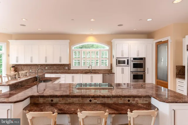 a large white kitchen with a large window and counter