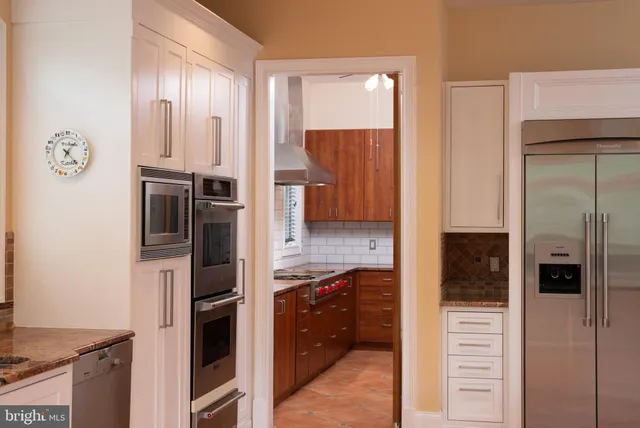 a kitchen with stainless steel appliances granite countertop a refrigerator and a stove