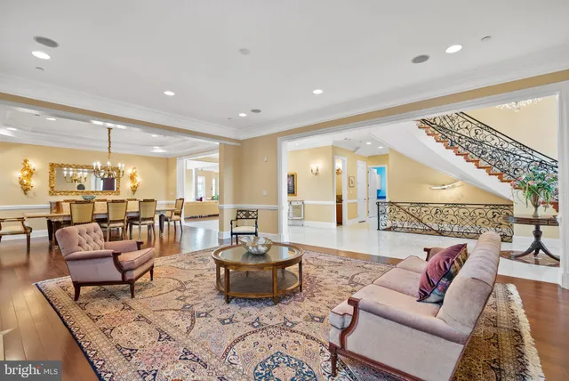 a dining room with wooden floor a chandelier a wooden table and chairs