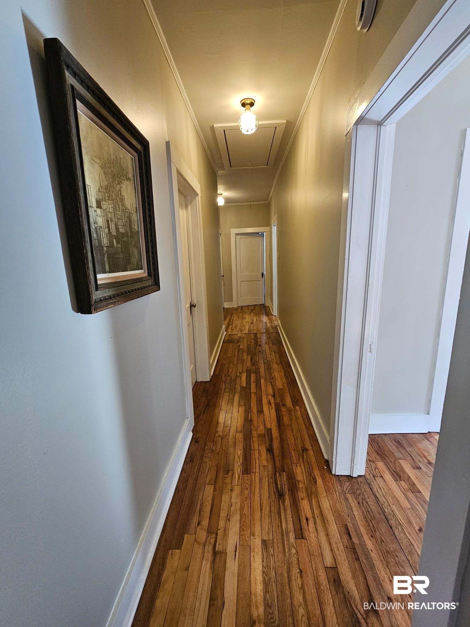 1215 Church Street Mobile, AL 36604 - Photo 12 of 23 Hallway with attic access, ornamental molding, dark wood finished floors, and baseboards