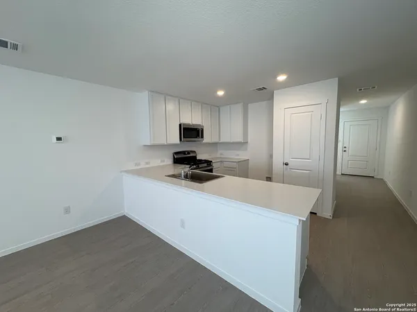 a kitchen with kitchen island a sink stainless steel appliances and cabinets