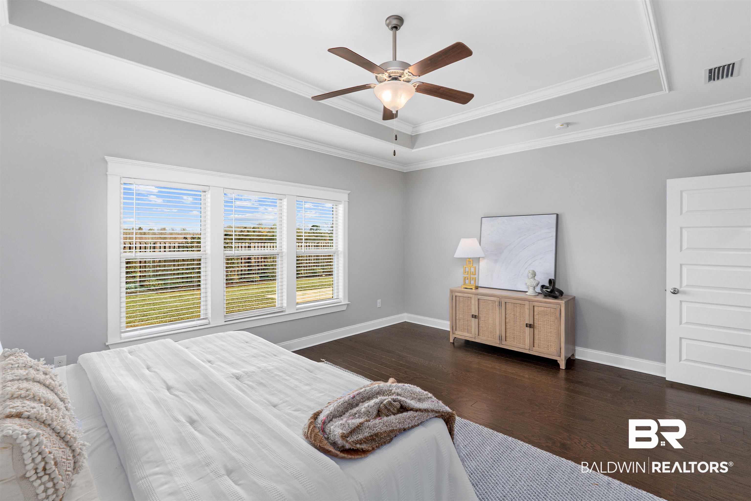 24838 Slater Mill Road Daphne, AL 36526 - Photo 34 of 46 Bedroom featuring a raised ceiling, dark wood finished floors, crown molding, and a ceiling fan