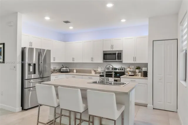 a kitchen with stainless steel appliances a refrigerator and a stove top oven