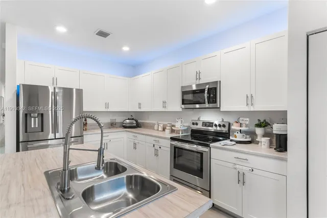 a kitchen with stainless steel appliances granite countertop a sink stove and cabinets