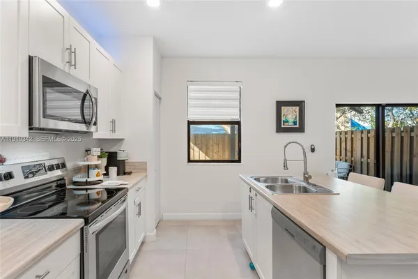 a kitchen with stainless steel appliances a stove sink microwave and cabinets
