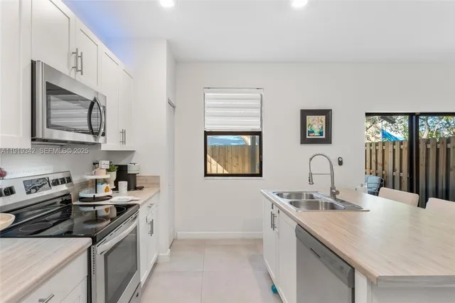 a kitchen with stainless steel appliances a stove sink microwave and cabinets