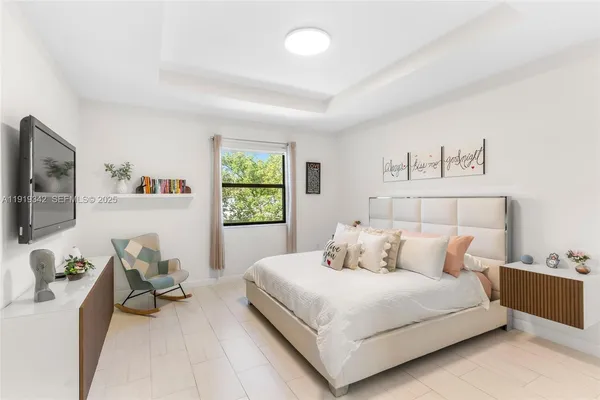 a bedroom with a bed and a flat screen tv