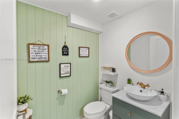 a bathroom with a toilet a sink and mirror