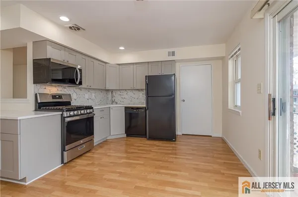 a kitchen with stainless steel appliances granite countertop a refrigerator and a stove top oven