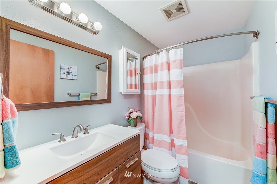 2319 Cherry Road Lake Stevens, WA 98258 - Photo 16 of 25 a bathroom with a sink a toilet a mirror a vanity a bathtub and shower