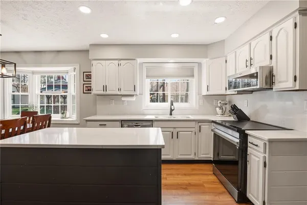 a kitchen with stainless steel appliances granite countertop a sink stove and cabinets