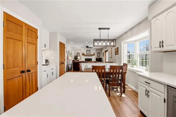 a kitchen with stainless steel appliances a table chairs refrigerator and cabinets