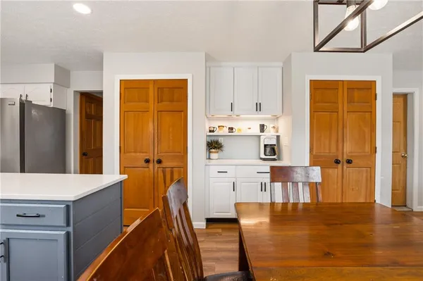 a kitchen with stainless steel appliances wooden floor and large window