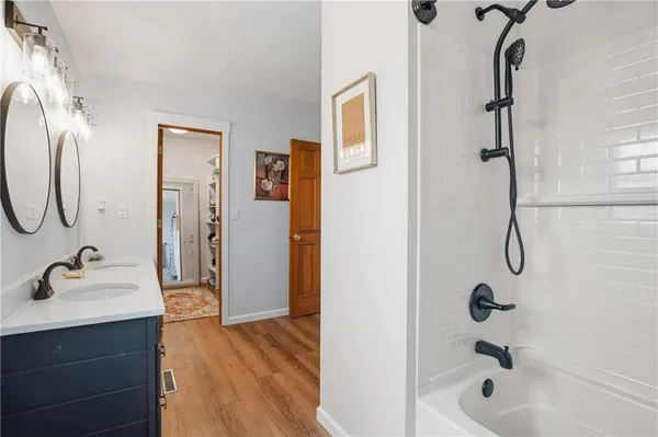 a bathroom with a tub sink and mirror