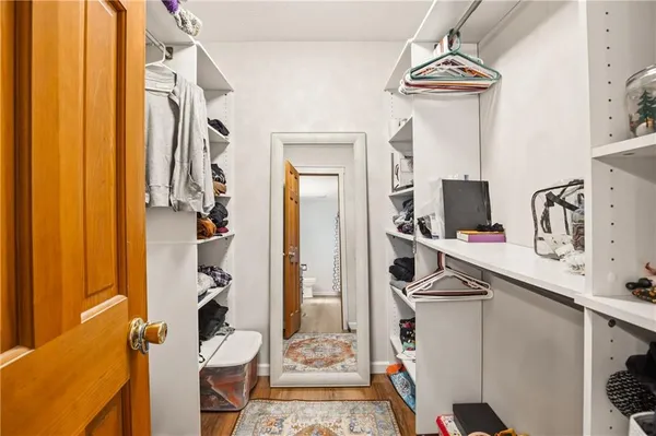 a view of walk in closet with clothes and shoes