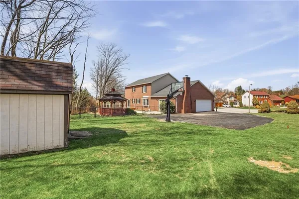 a view of a house with a big yard and large trees