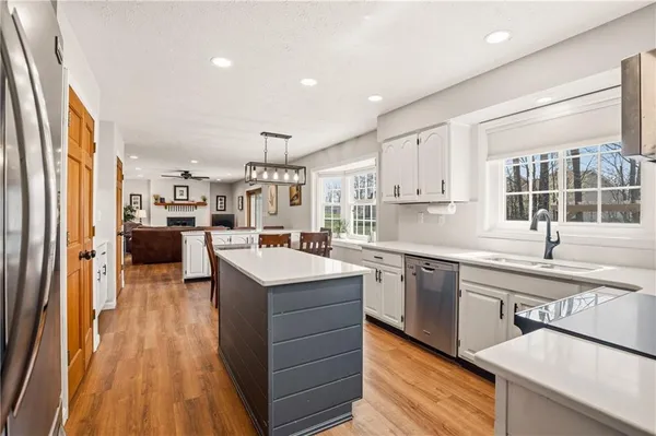 a kitchen with stainless steel appliances granite countertop a sink stove and wooden floor
