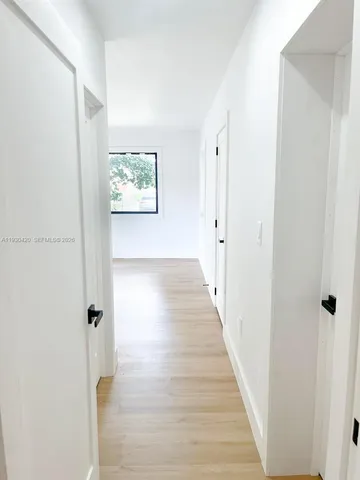 a view of a hallway with wooden floor and closet area