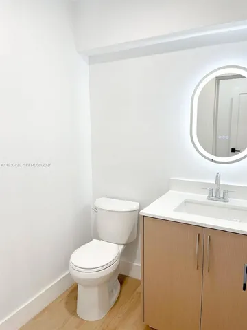 a bathroom with a toilet a sink and mirror