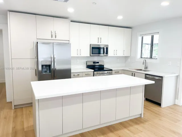 a kitchen with stainless steel appliances a microwave sink and refrigerator