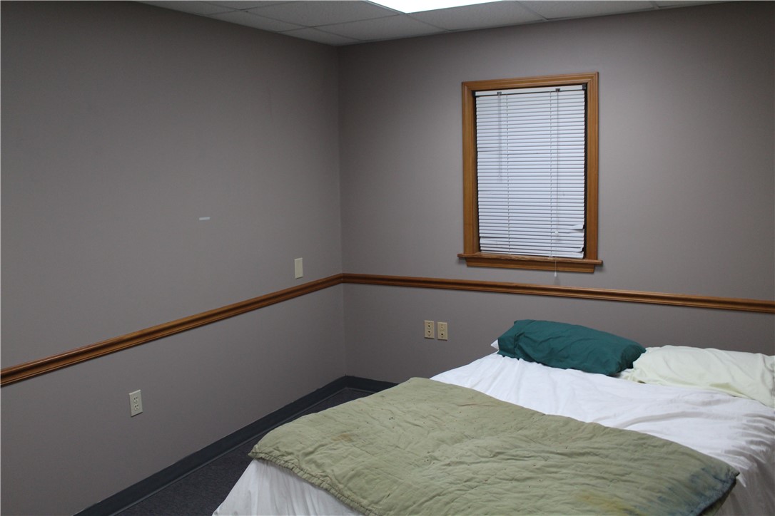 158 Ragon Road Tilly, AR 72679 - Photo 13 of 51 Interior room featuring a wood-trimmed window with blinds, neutral wall tones, and a drop ceiling