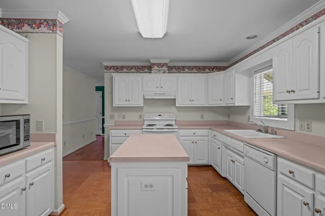 a kitchen with cabinets appliances a sink and a counter space
