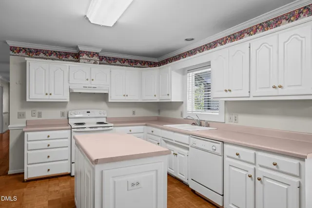 a kitchen with white cabinets and white appliances