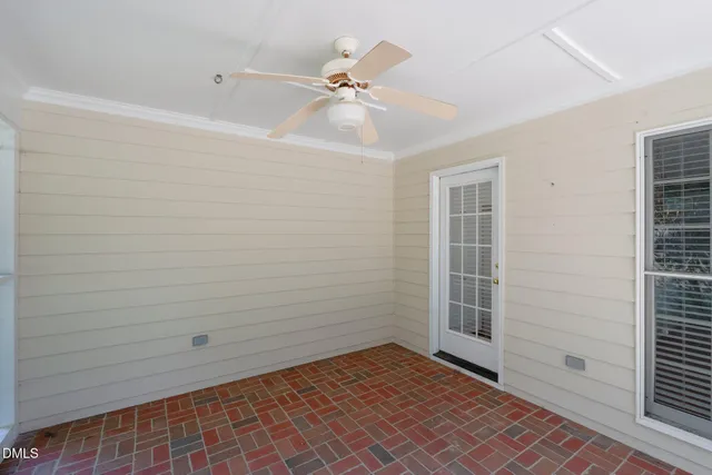 a front view of a house with a yard and potted plants