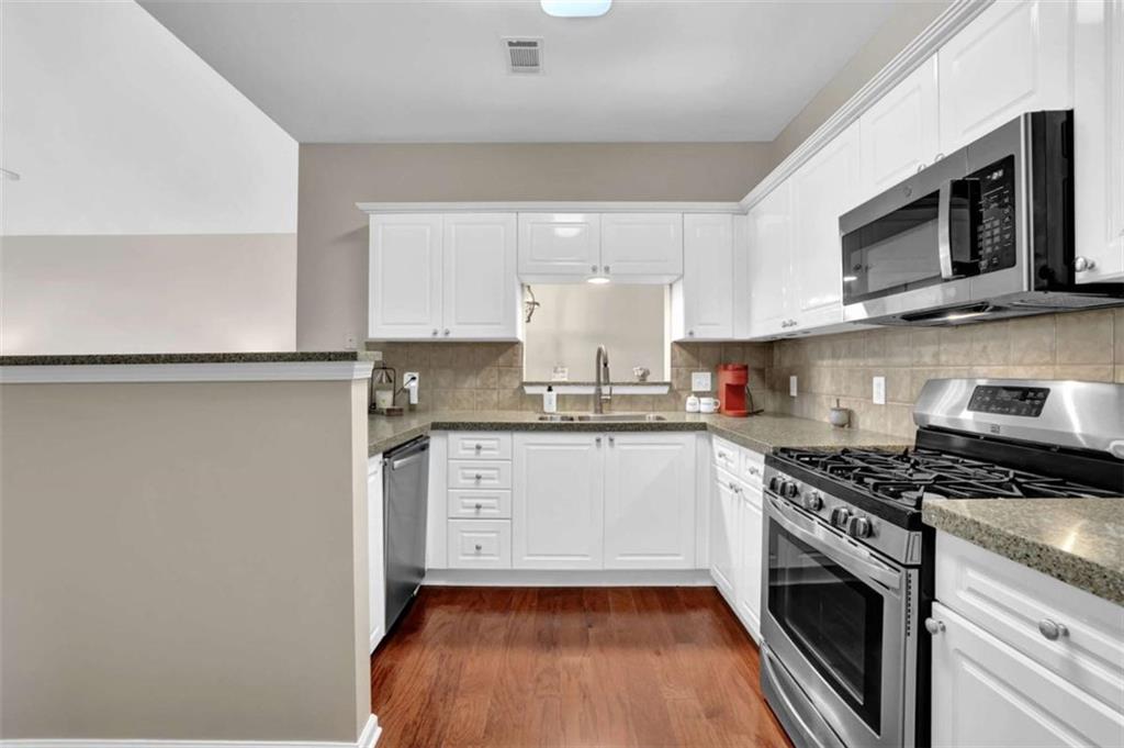 140 Stonegate Lane Canton, GA 30114 - Photo 17 of 38 a kitchen with granite countertop white cabinets stainless steel appliances and sink