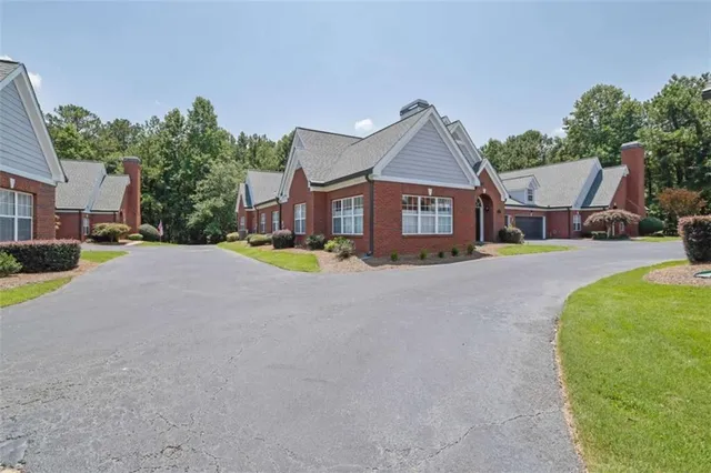 a view of a house with a big yard and large trees