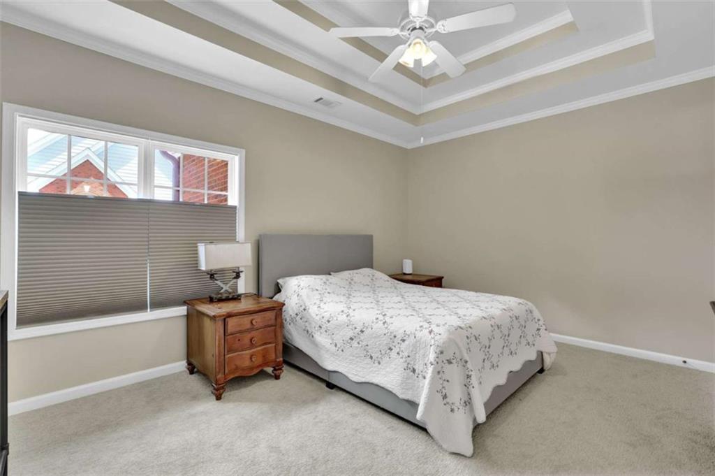 140 Stonegate Lane Canton, GA 30114 - Photo 21 of 38 a spacious bedroom with a bed and a chandelier