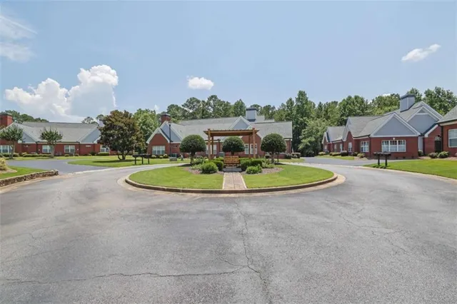 a view of a white house with a swimming pool and a yard