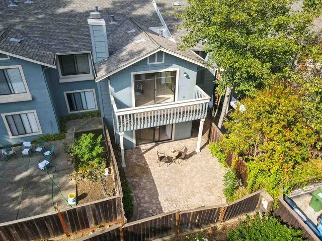 a view of a brick house with wooden fence and large windows